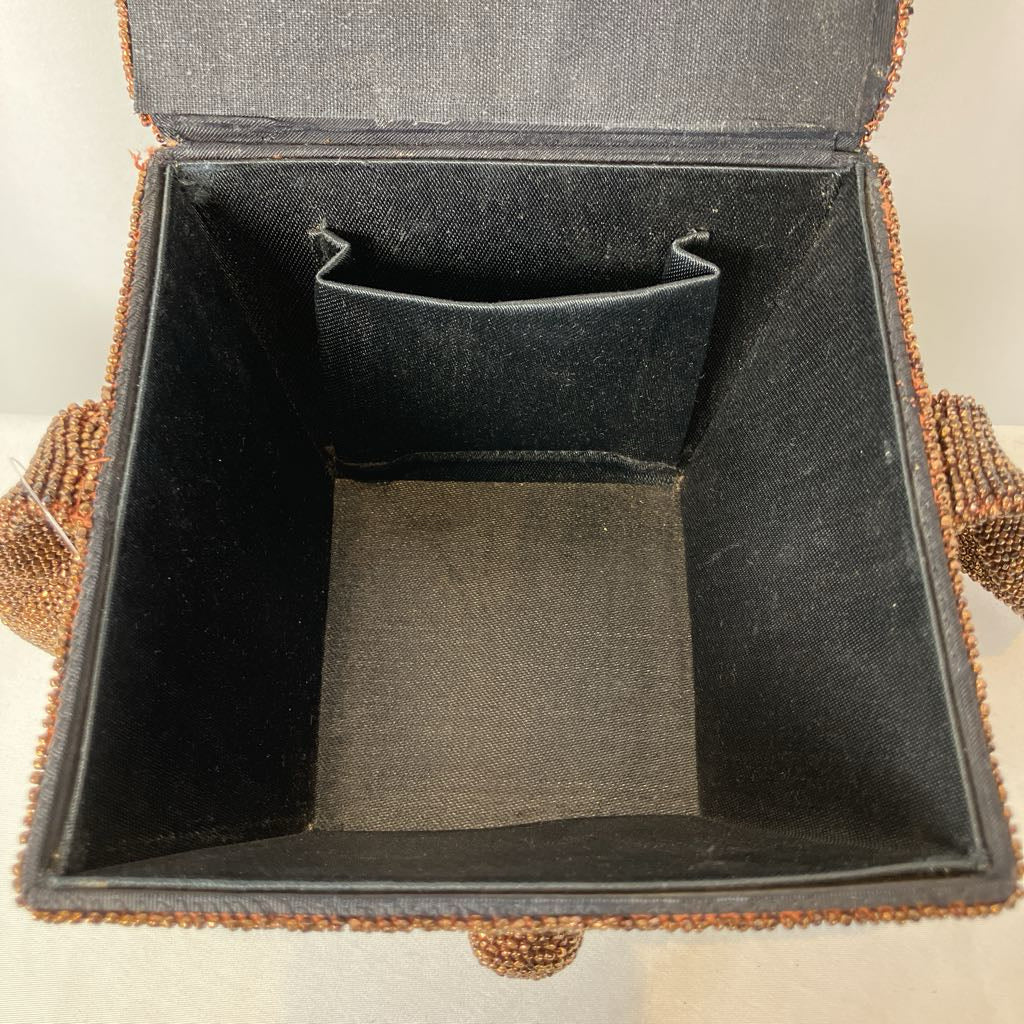 Open jewelry box with black interior and decorative brown exterior.