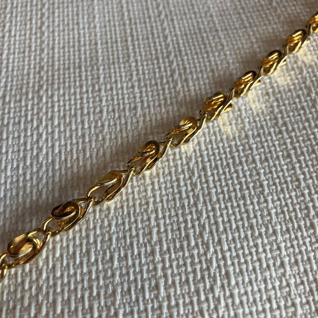 Gold chain on a textured beige background