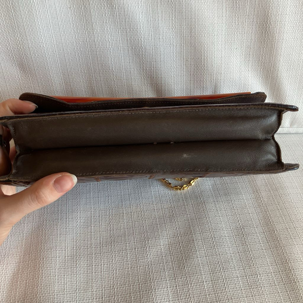 Brown leather wallet held open against a light fabric background