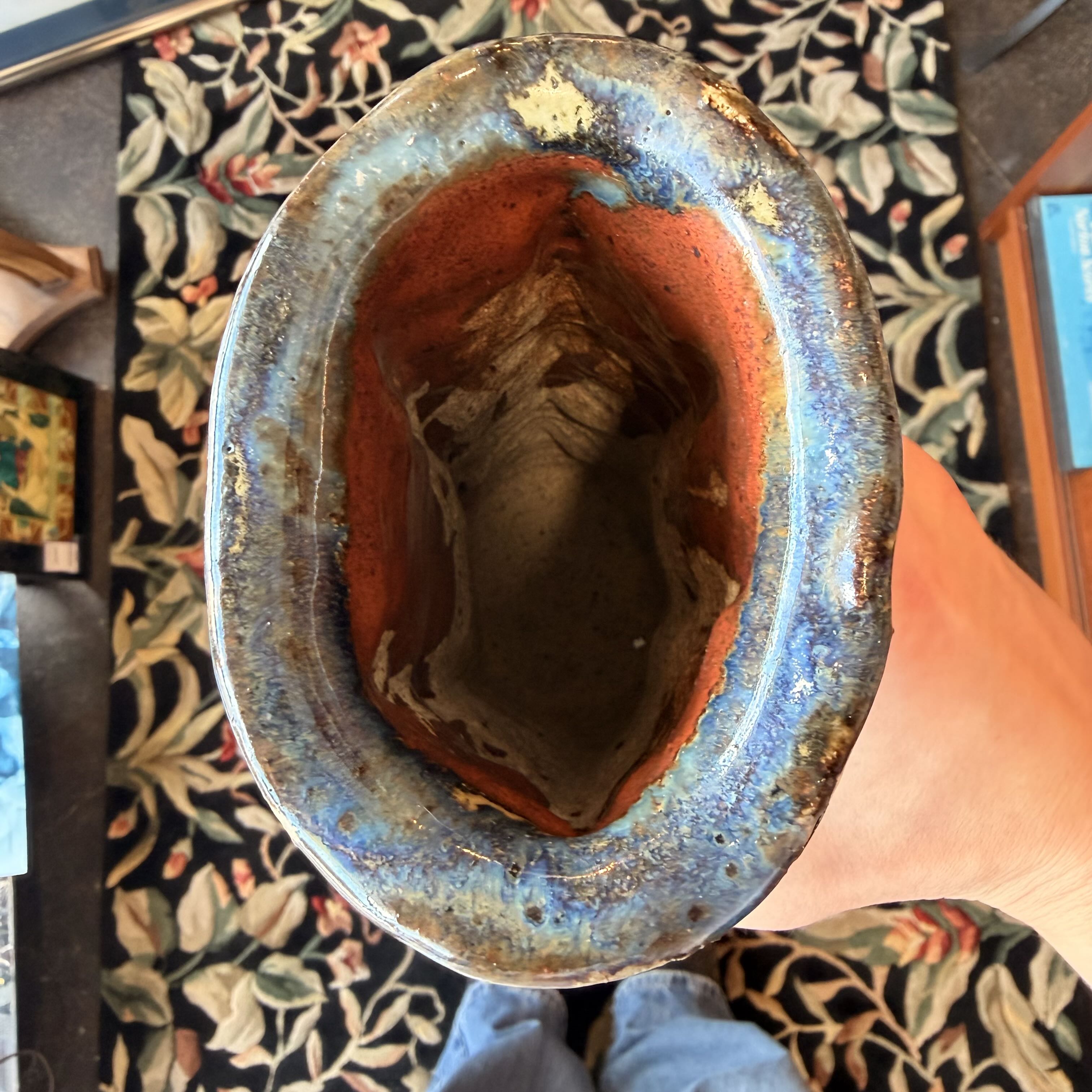 Hand holding a ceramic bowl with a floral pattern on a table