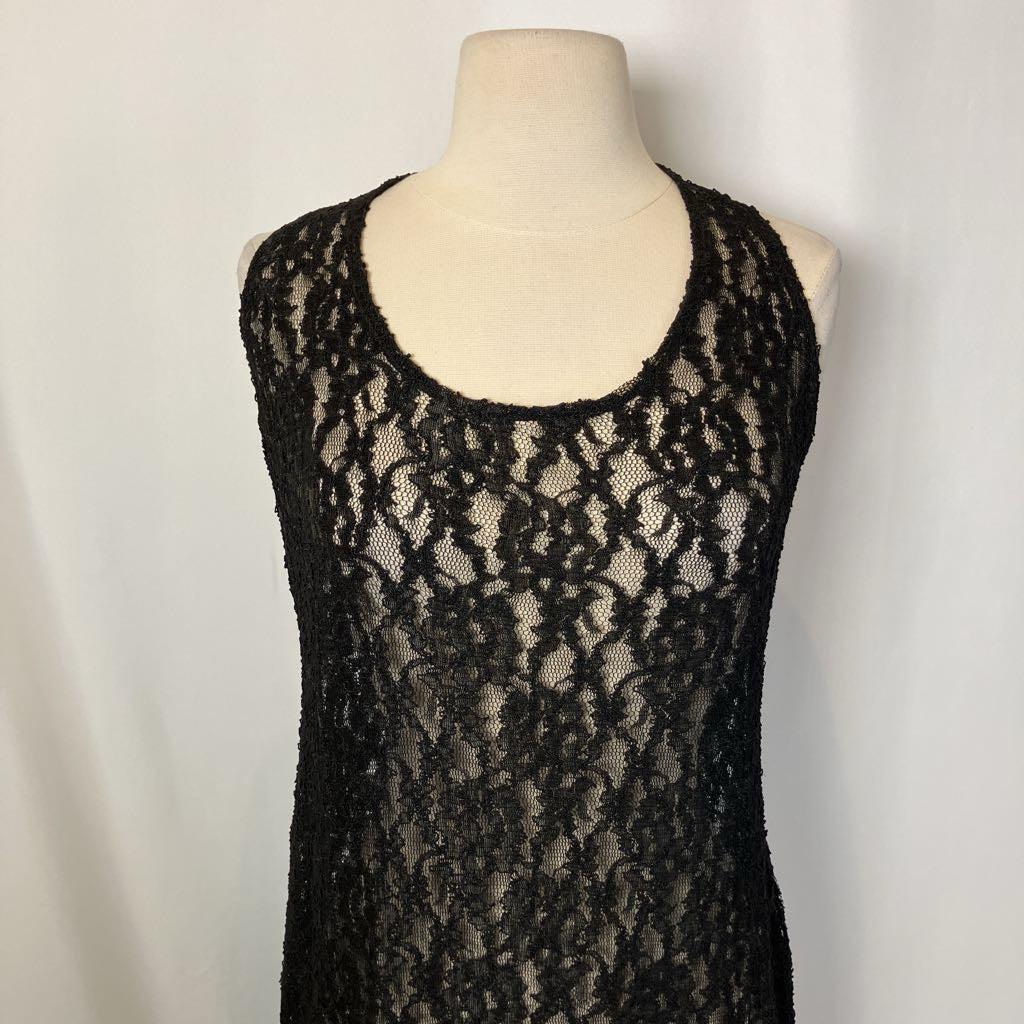 Black lace dress on a mannequin against a plain background