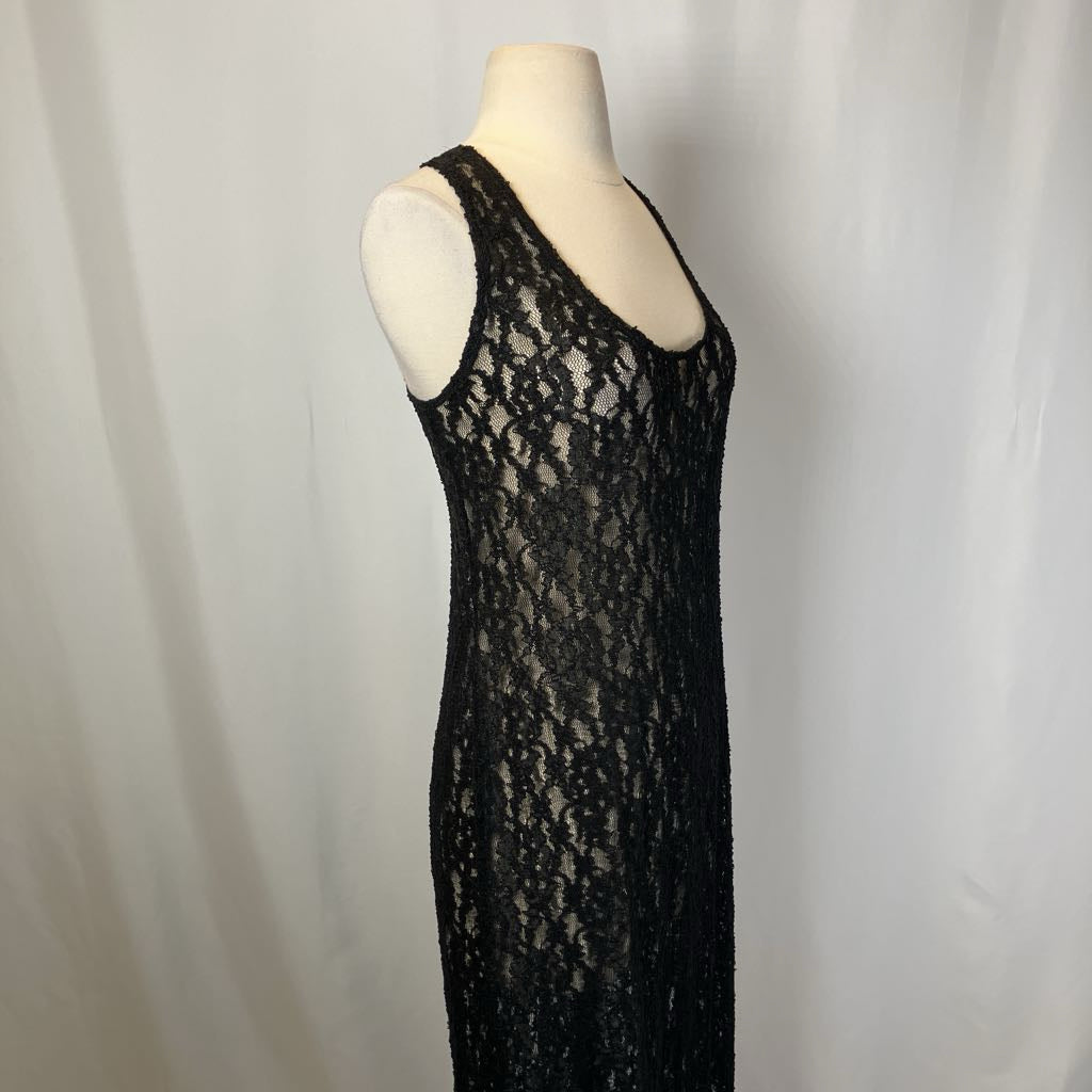 Black lace dress on a mannequin against a plain background