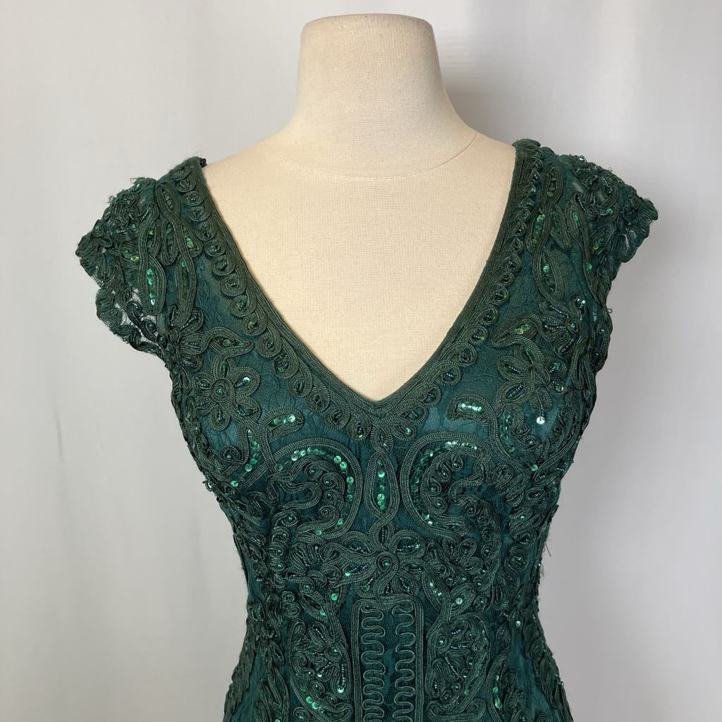 Green sequin dress on a mannequin against a plain background