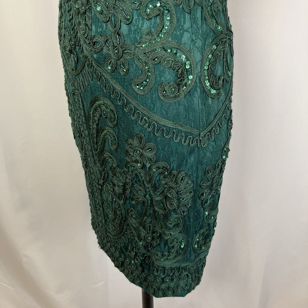 Teal embroidered fabric on a mannequin against a white background