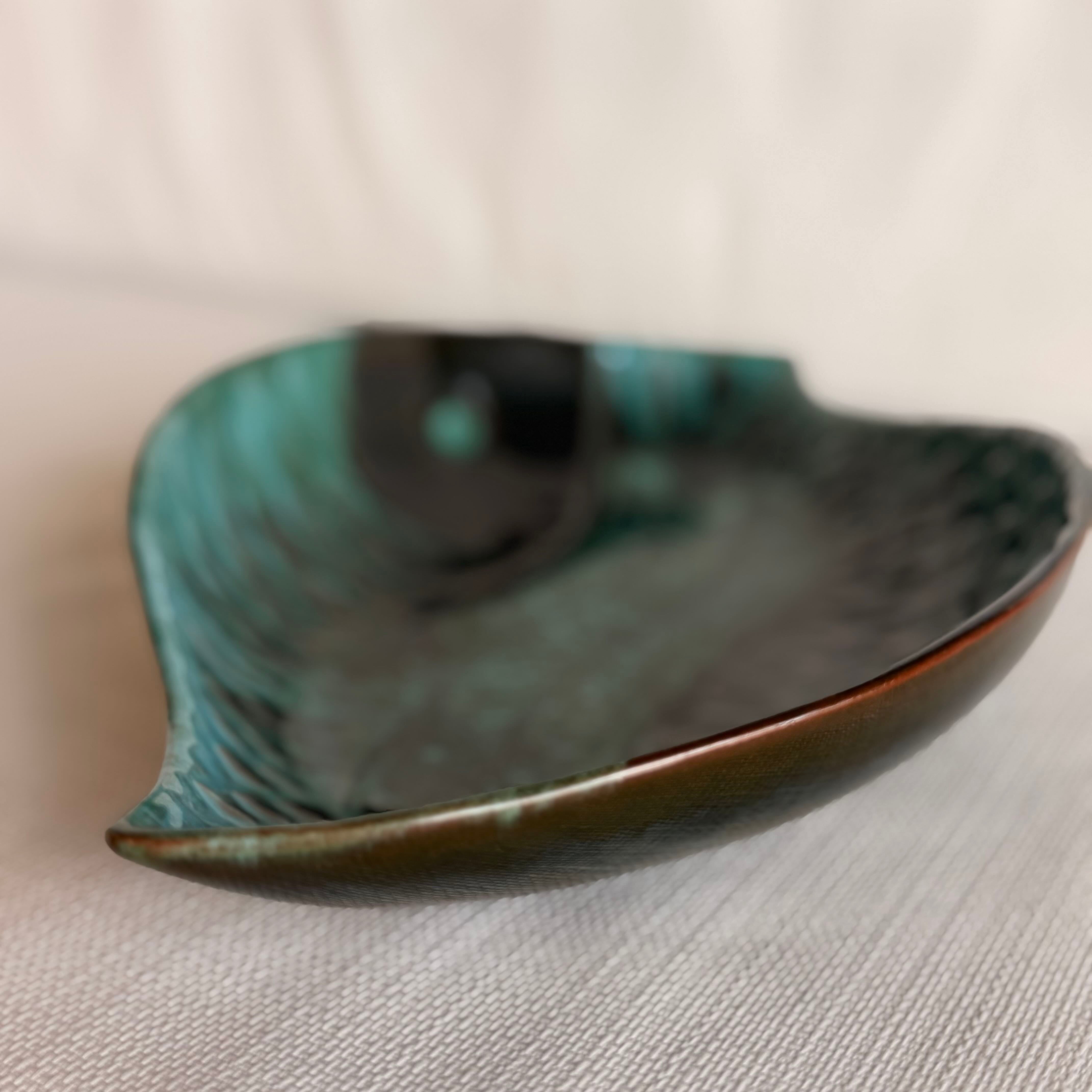 Teal and black ceramic dish on a light gray surface