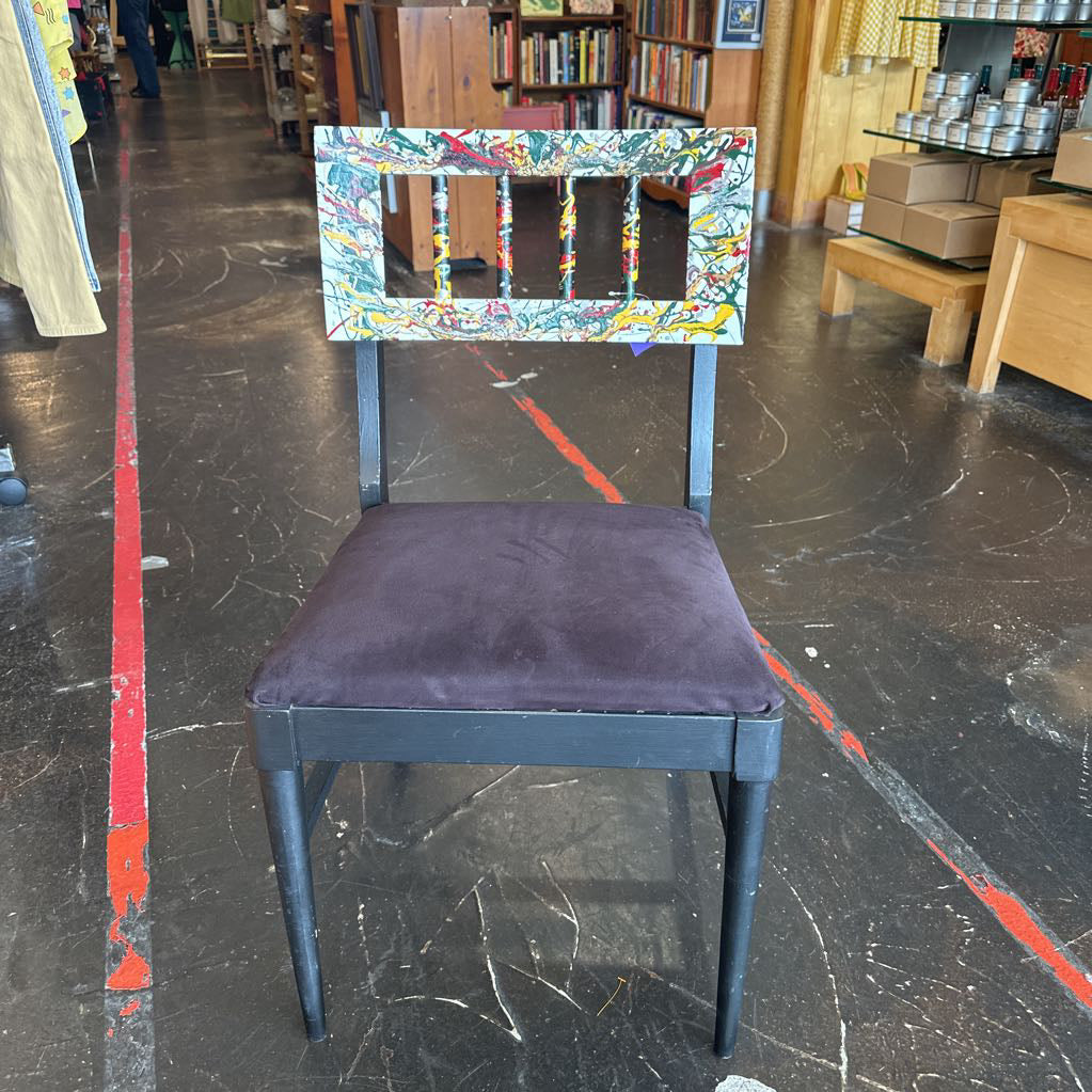 Chair with a colorful backrest and dark seat in an indoor setting