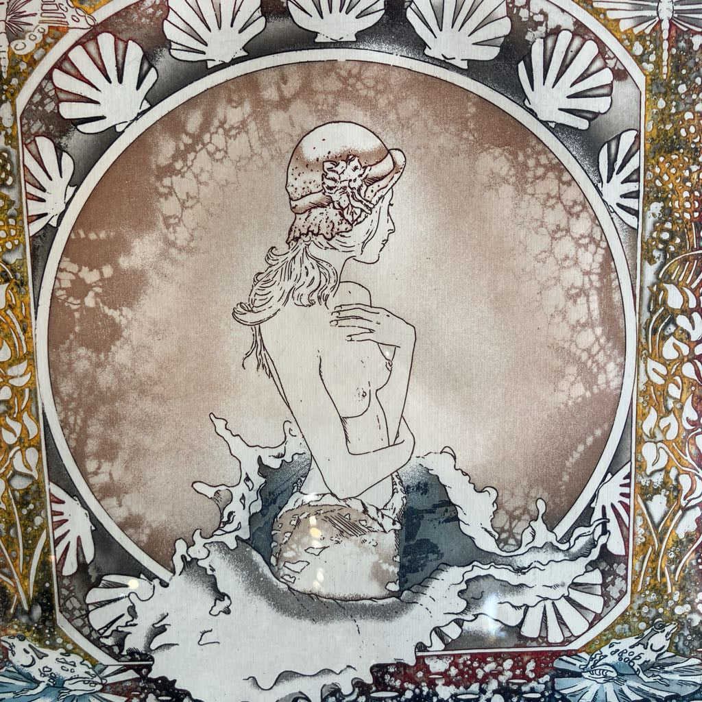 Artistic depiction of a mermaid sitting on a shell with decorative shell patterns around.