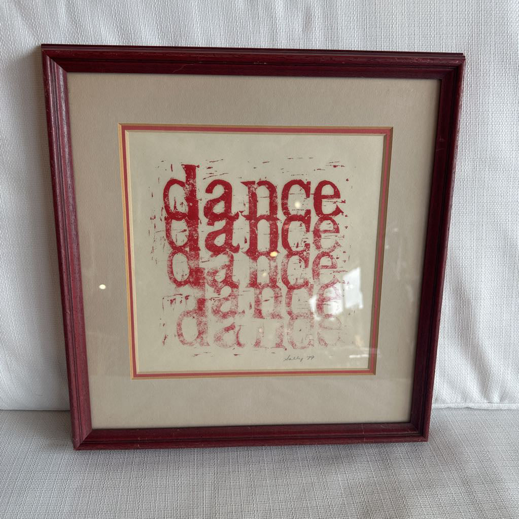 Framed artwork with 'dance' text in red on a beige background