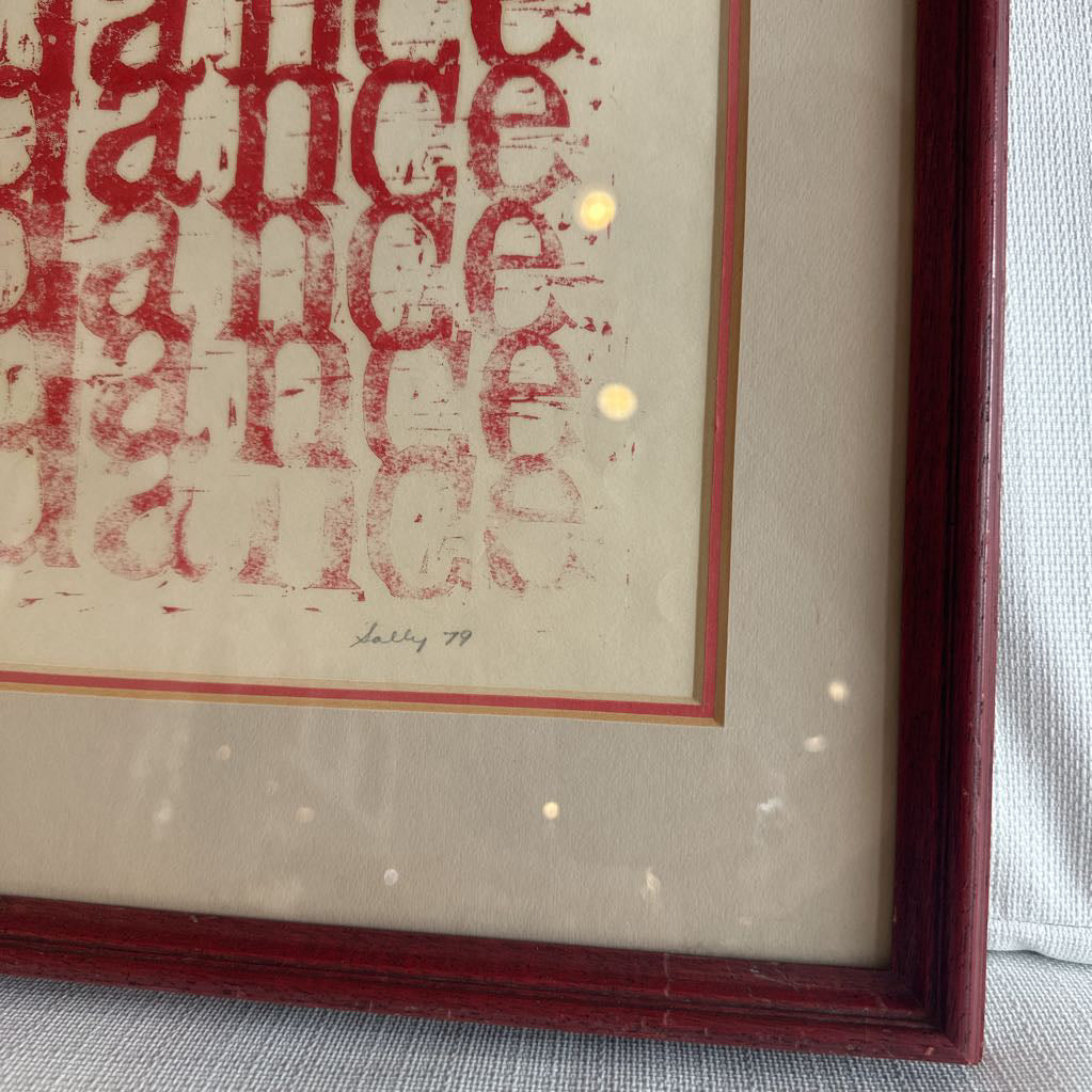Framed artwork with red text on a textured surface