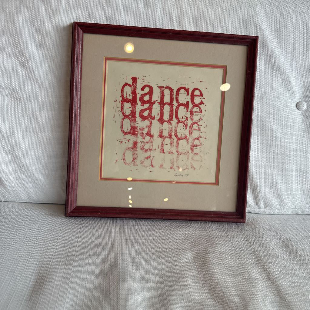 Framed artwork with the red text on a white background.