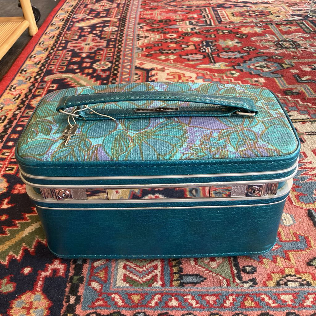 Blue vanity case with floral pattern on a colorful rug
