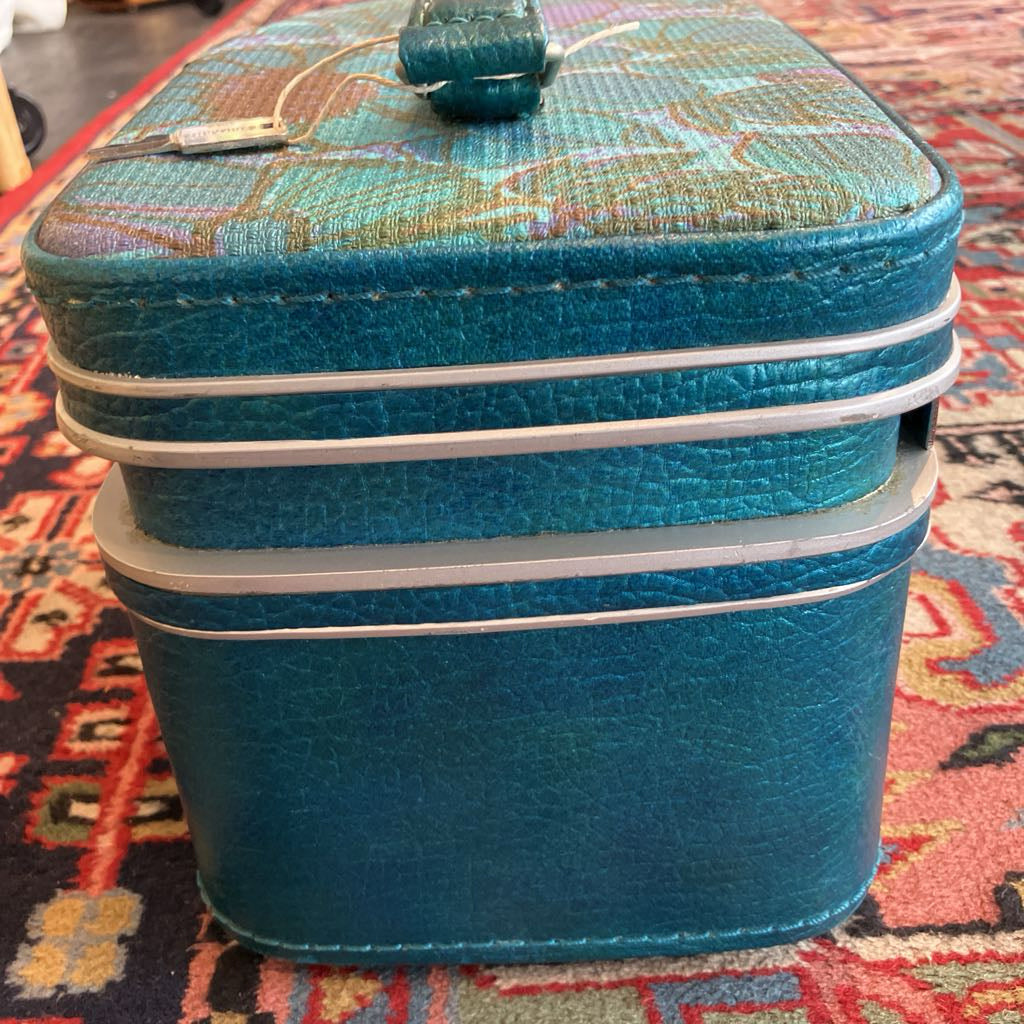 Blue textured suitcase on a patterned rug