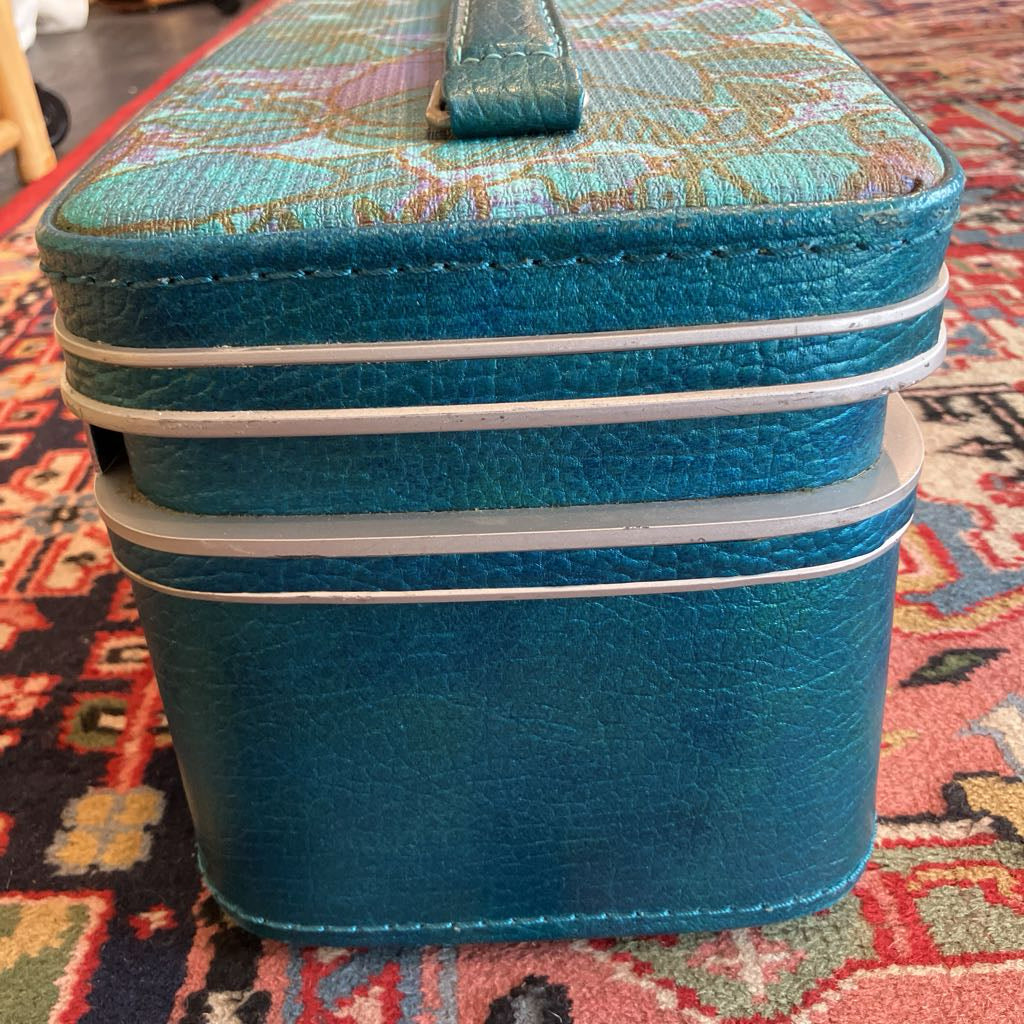 Blue textured suitcase on a patterned rug