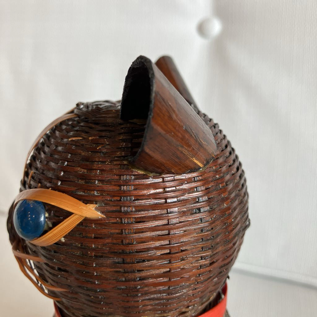 Wicker basket with a blue stone and wooden handle on a white background