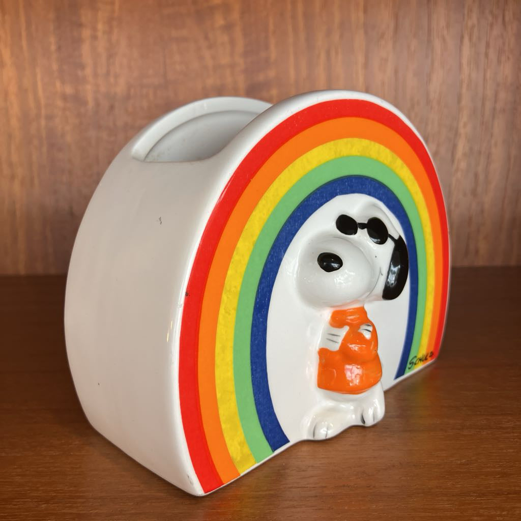 Ceramic container with Snoopy design and rainbow colors on a wooden surface