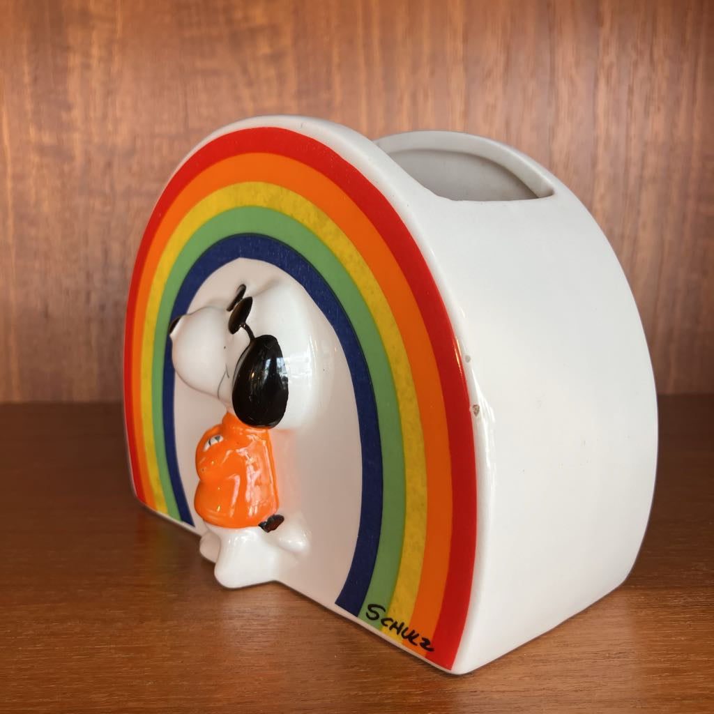 Snoopy figurine with rainbow design on a wooden surface