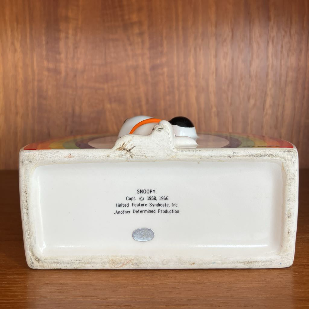 The underside of a white ceramic holder on a wooden surface