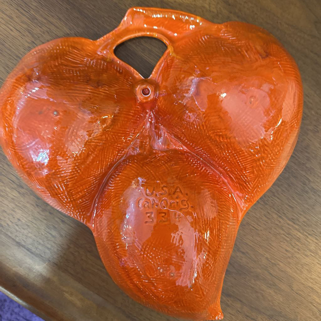 Orange plastic saddle on a wooden surface