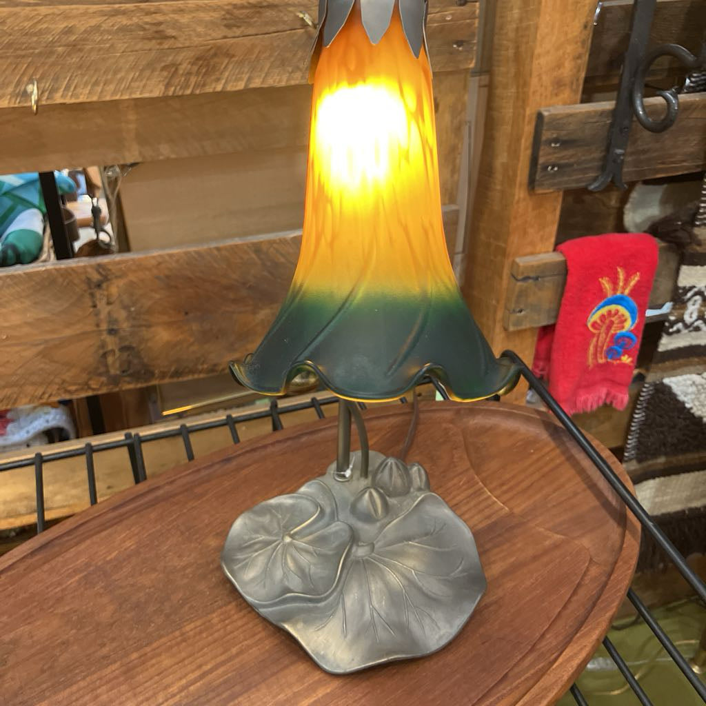 Decorative lamp with a colorful glass shade on a wooden table.