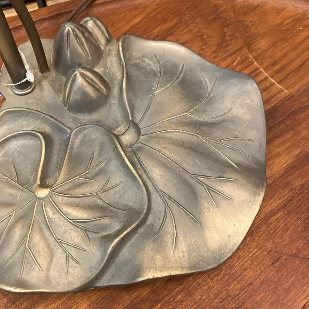 Metallic leaf-shaped object on a wooden surface