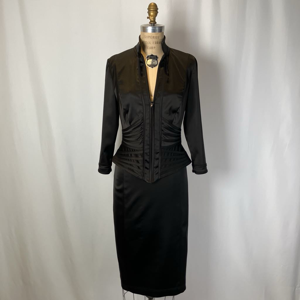 Black dress on a mannequin against a plain background