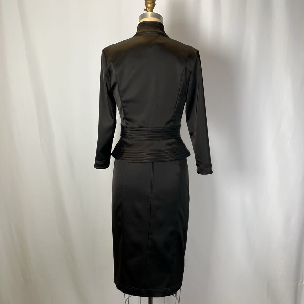 Black dress on a mannequin against a plain background