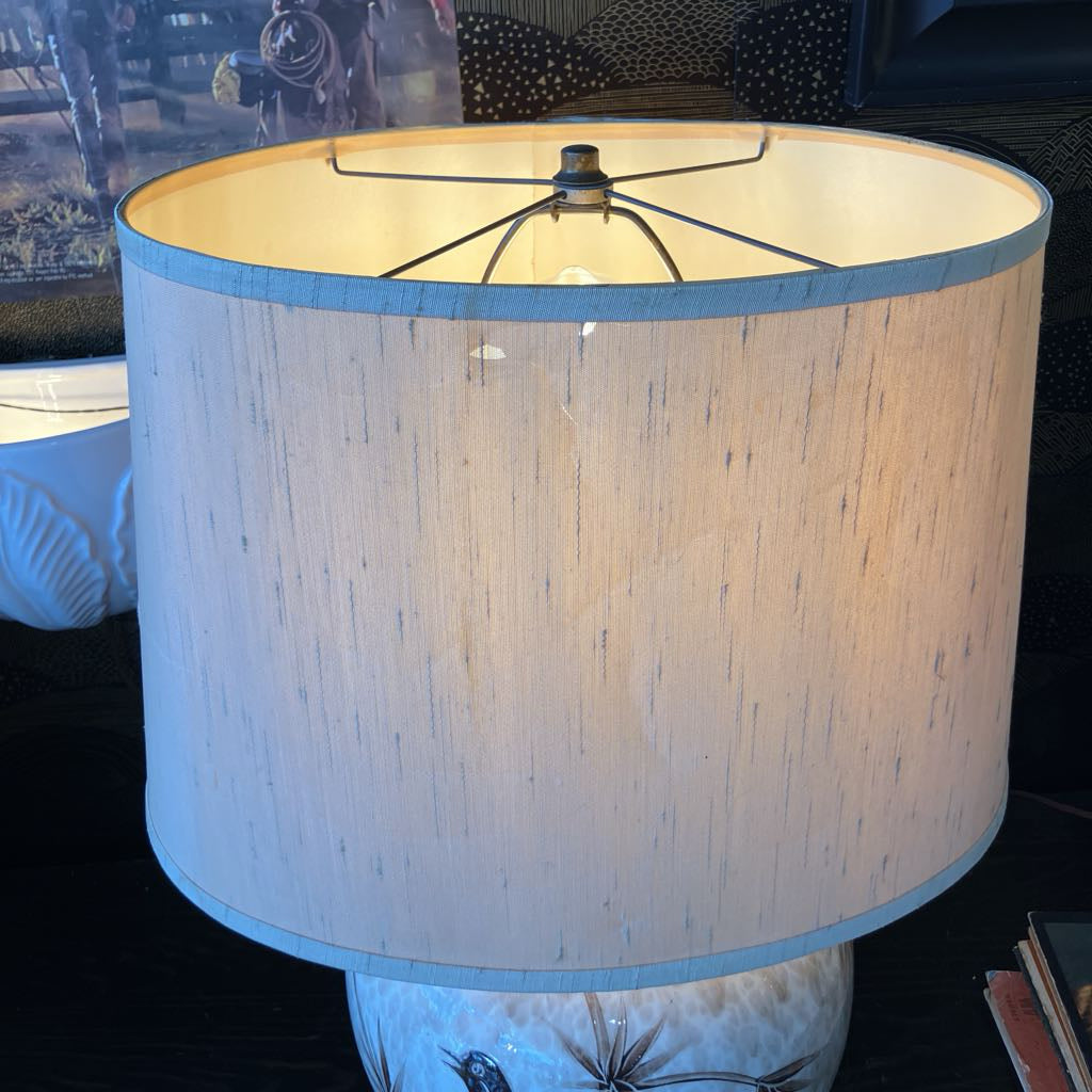 Lamp with a textured beige shade on a dark background