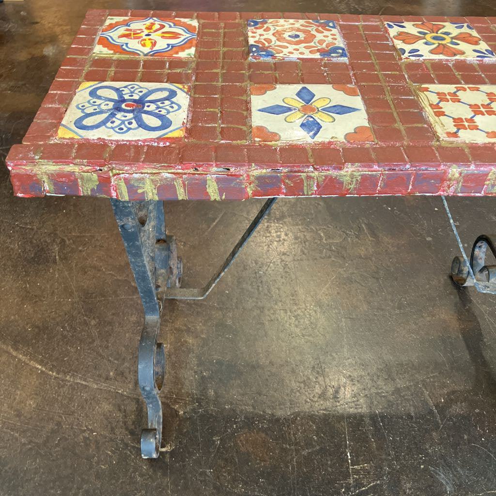 Tiled table with decorative patterns on a concrete floor