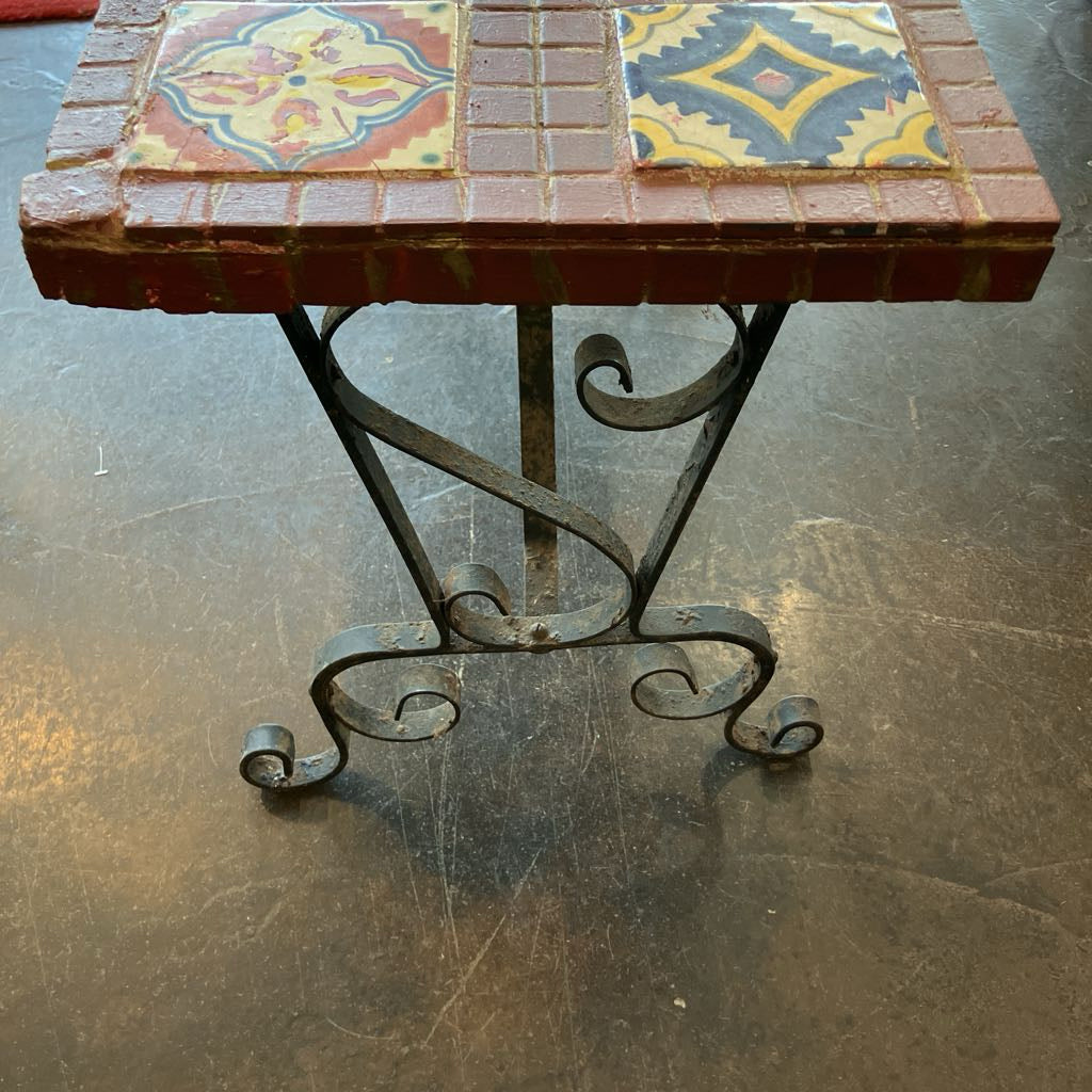 Small table with decorative tiles on a concrete floor