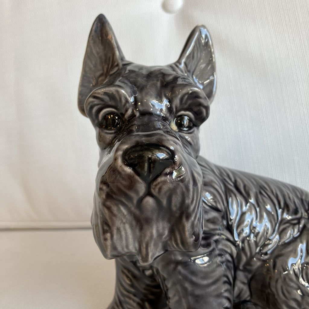 Ceramic dog figurine with a detailed coat pattern on a plain background