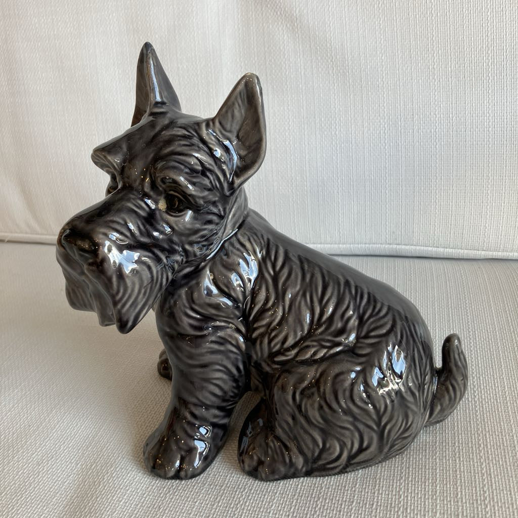 Ceramic dog figurine on a beige surface
