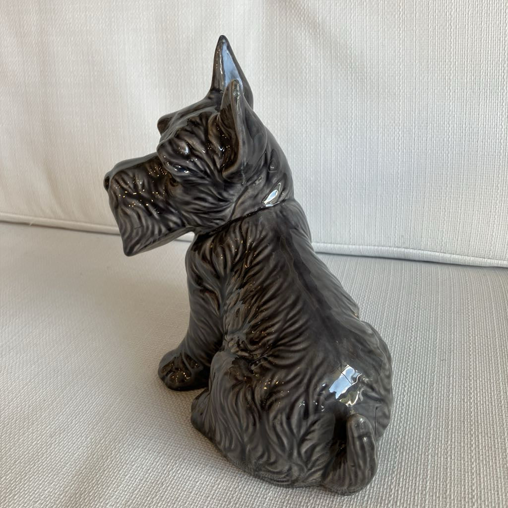 Black ceramic dog figurine on a beige surface