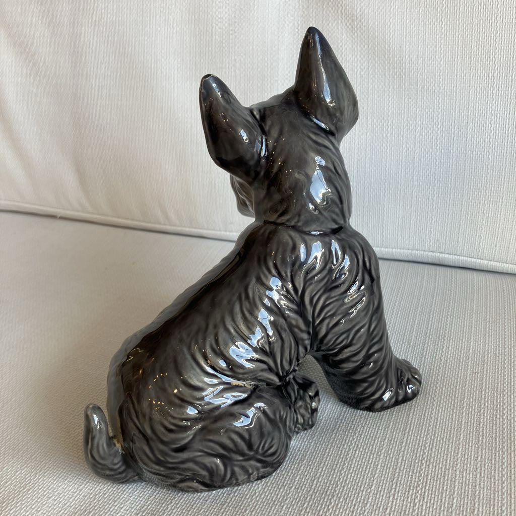 Ceramic dog figurine on a beige surface