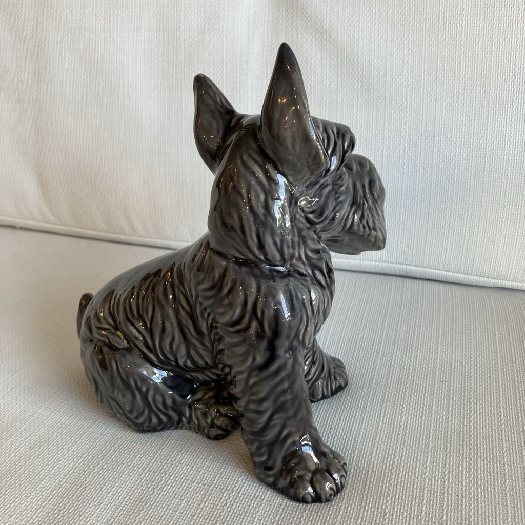 Ceramic dog figurine on a beige surface with a neutral background