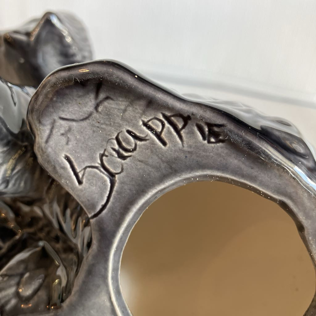 Close-up of a metallic object with 'Scrappie' engraving on a white background
