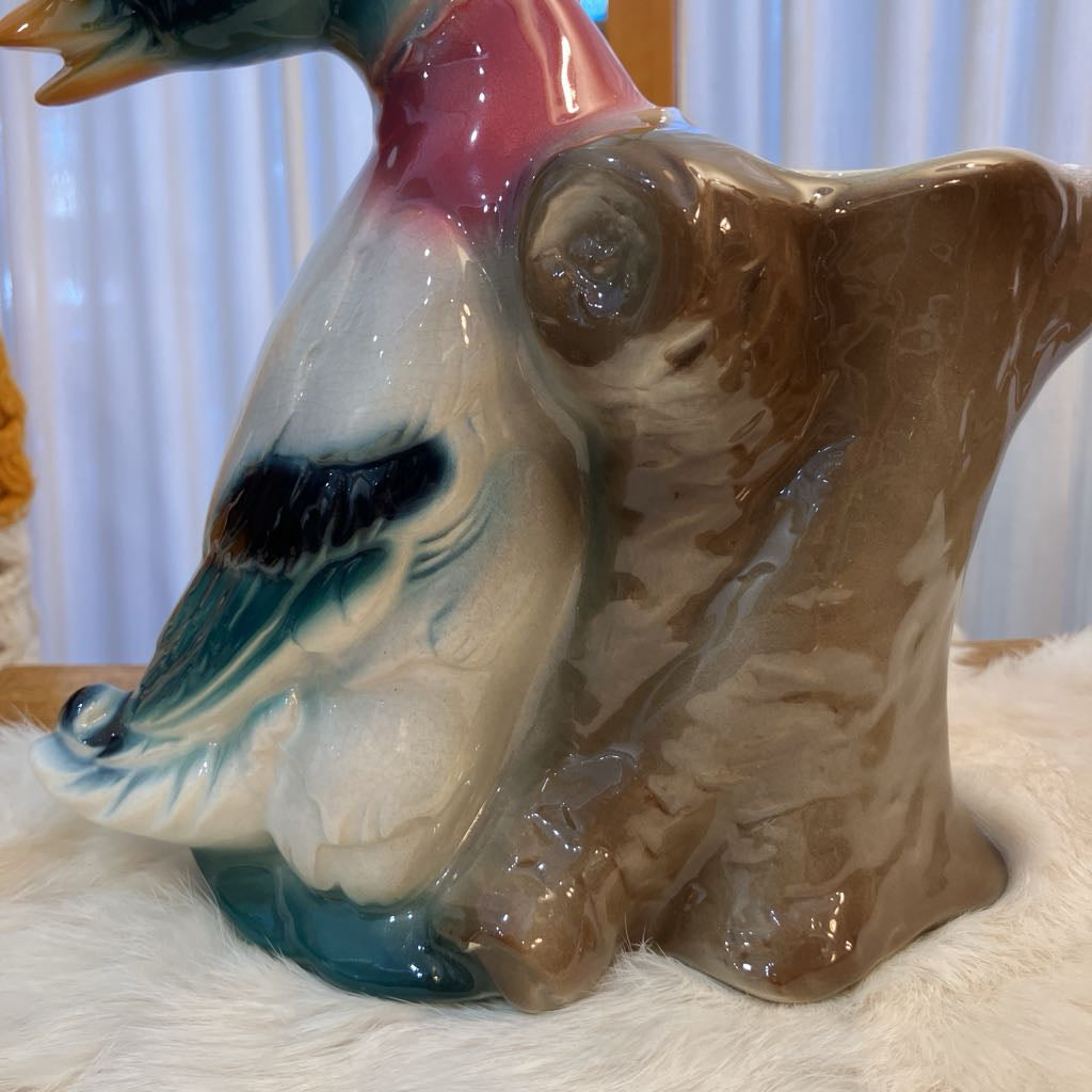 Ceramic duck figurine on a white surface with a blurred background