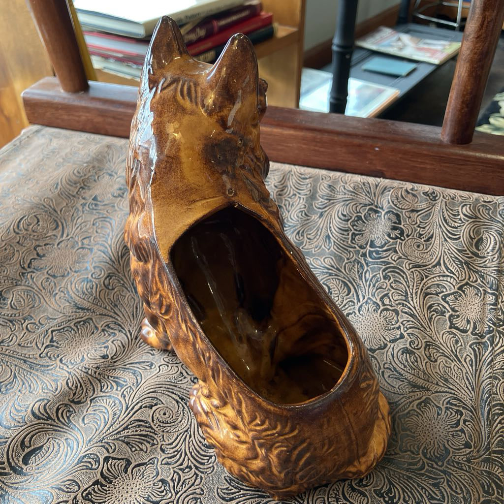 Brown ceramic dog planter on a patterned surface