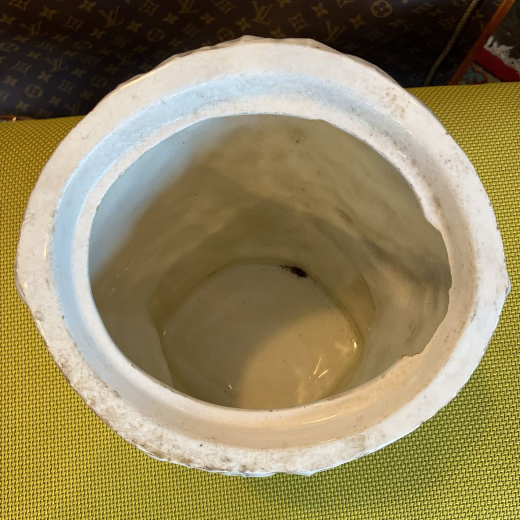 Ceramic pot with a textured surface on a green fabric background