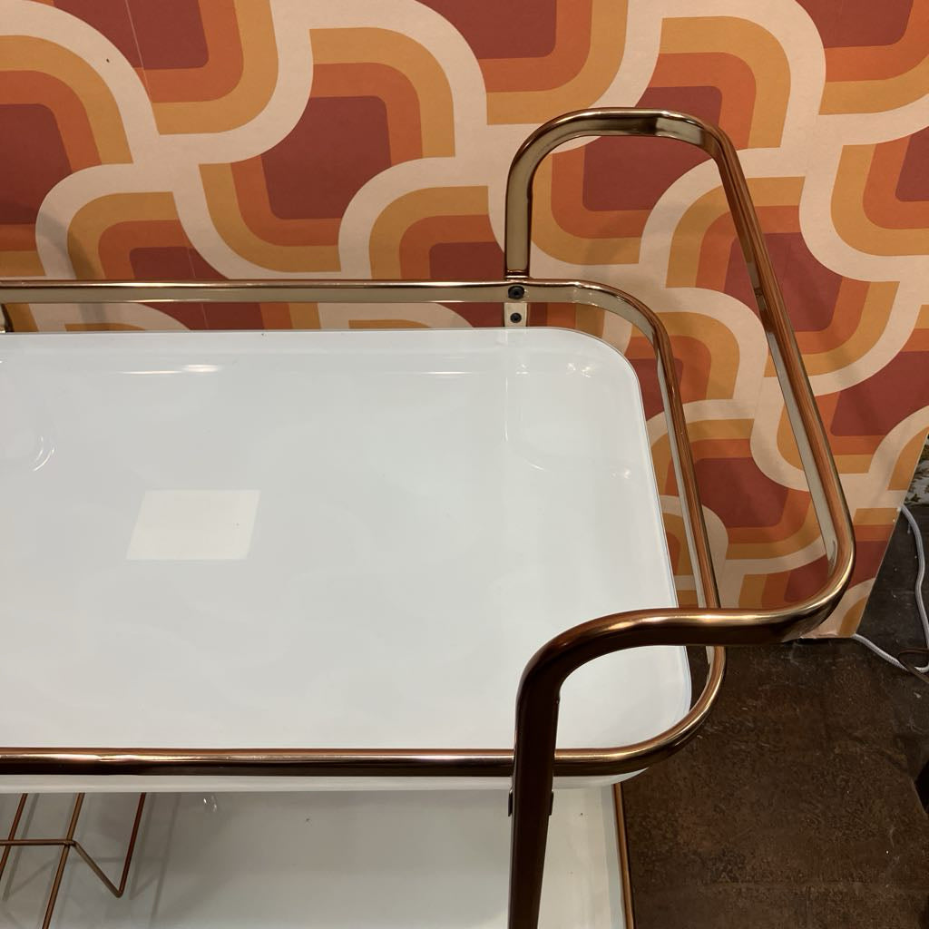 Metal chair with a white seat against a patterned wall.