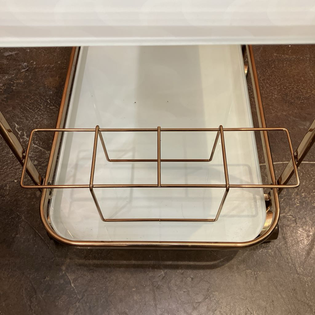 Glass tray with gold metal stand on a dark surface