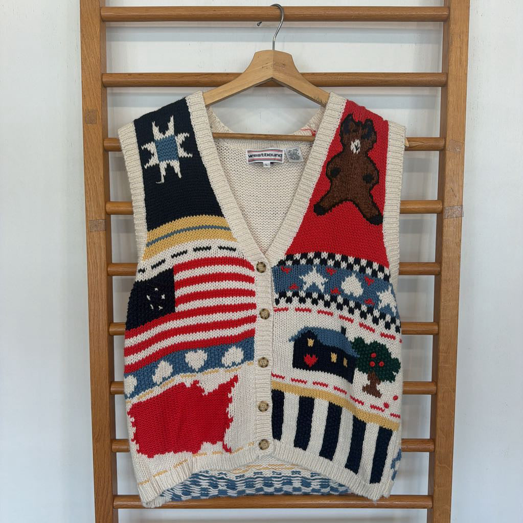 Colorful patterned sweater vest on a wooden rack against a white wall