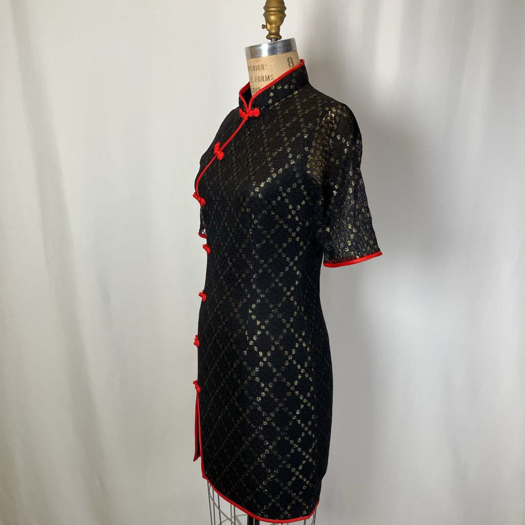 Black dress with red accents on a mannequin against a white background