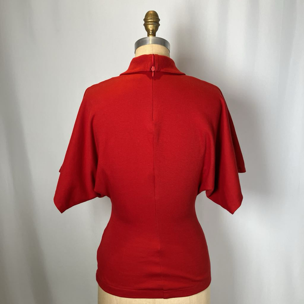 Red shirt on a mannequin against a plain background