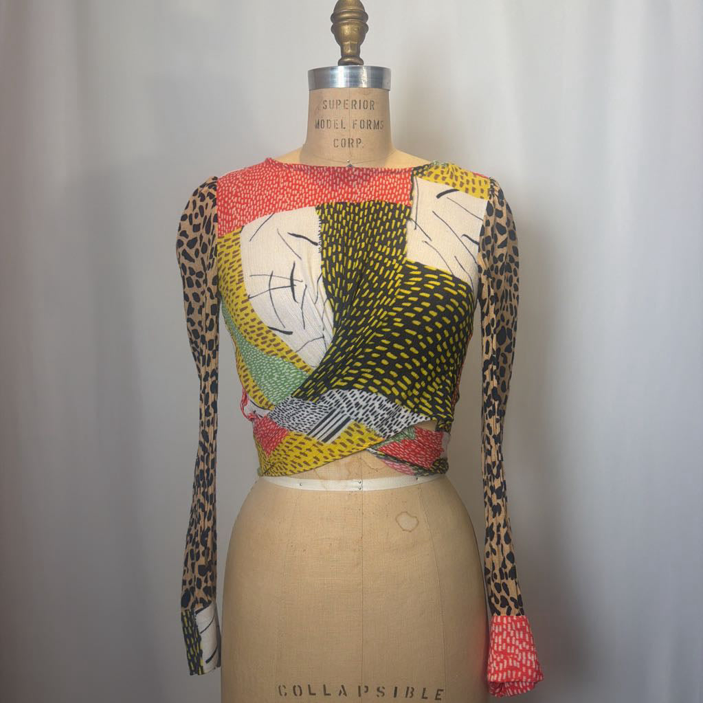 Colorful patterned top on a mannequin against a plain background
