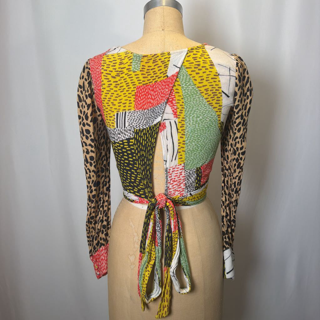 Colorful patterned top on a mannequin against a plain background