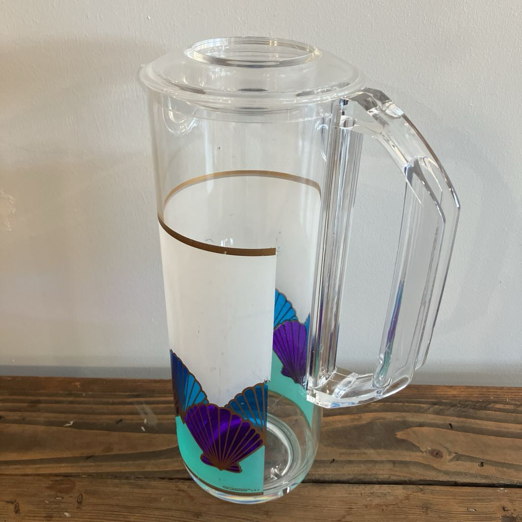 Clear pitcher with floral design on a wooden surface