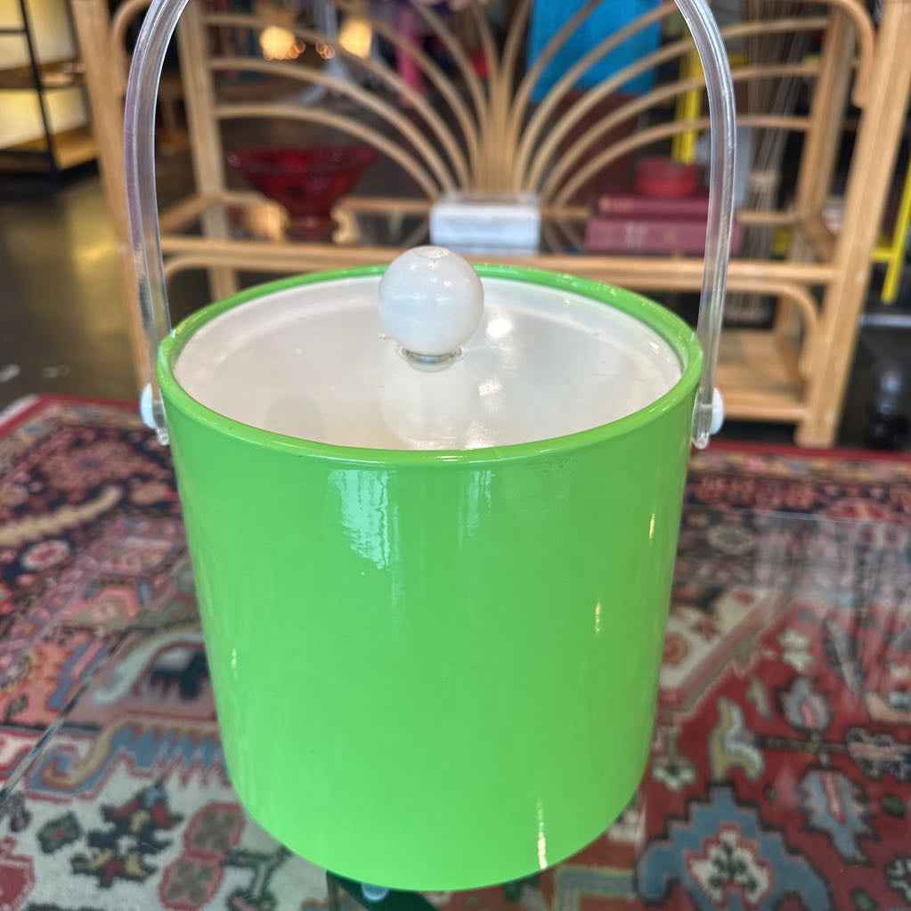 Green ice bucket with a clear handle on a patterned rug