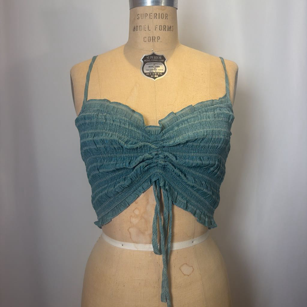 Green textured top on a mannequin against a plain background