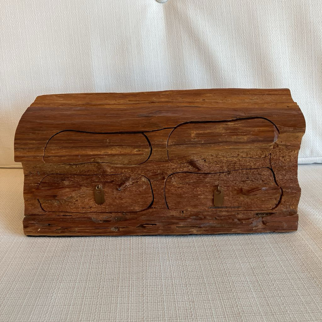 Wooden chest with carved designs on a beige surface