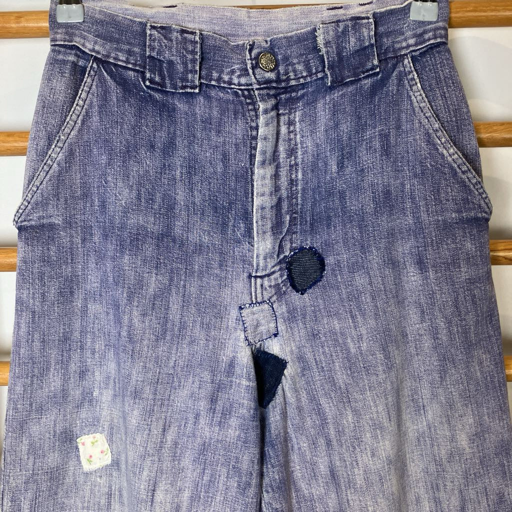 Blue denim jeans with a patch on a wooden rack